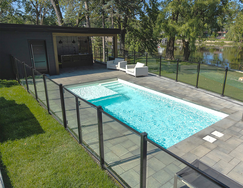 Une cour finie avec des clôtures de verre installées autour d'une piscine