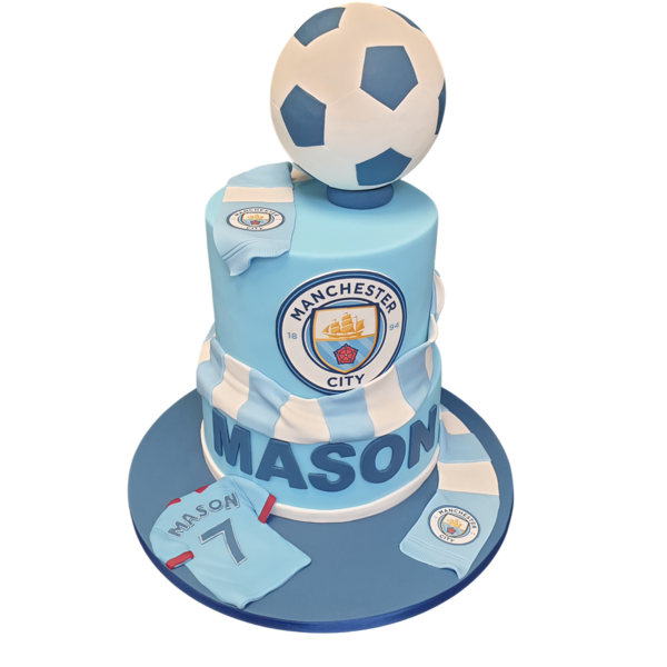 Bespoke Man City football-themed cake with blue and white icing, team crest, and football decorations in Solihull, West Midlands.