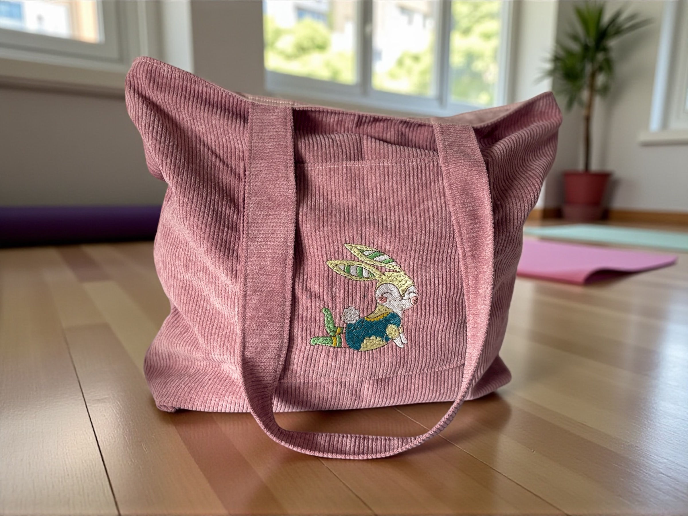 Pink Corduroy Tote Bag with embroidered rabbit doing an upward dog pose