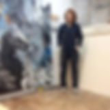 Image of artist standing in front of painting