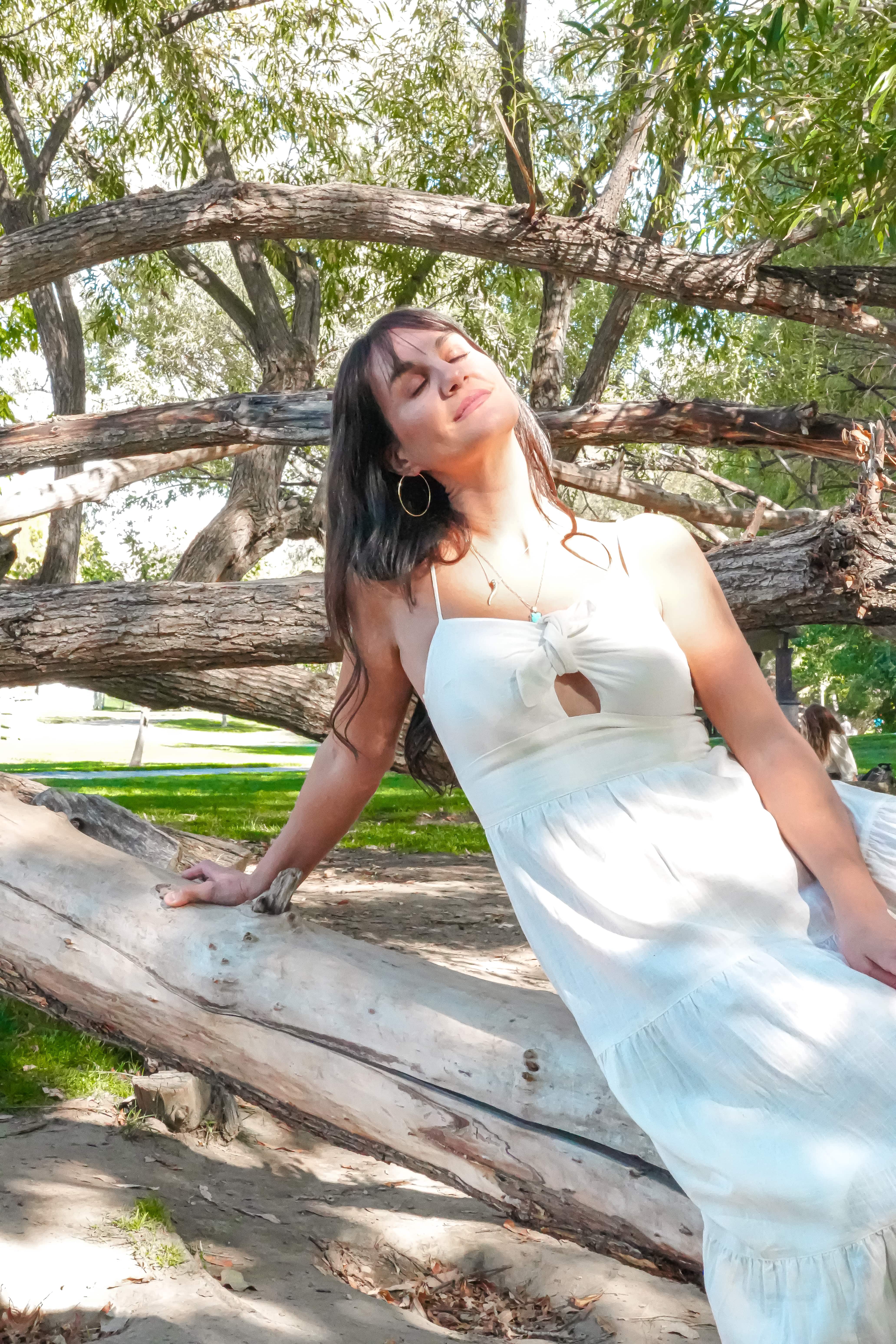 Tresa Rivera leaning against a fallen tree with her eyes closed