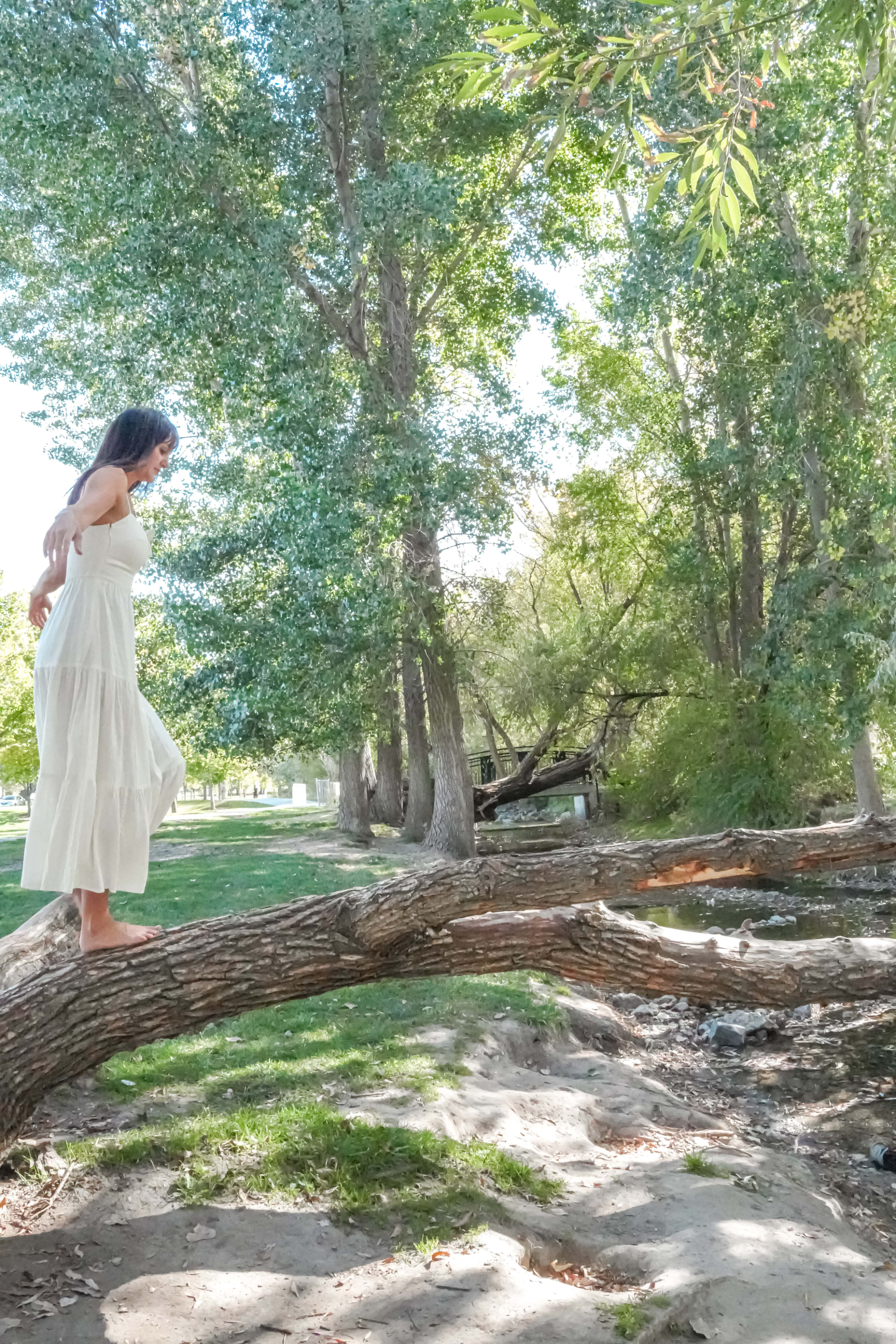 Tresa walking barefoot along a fallen tree trunk
