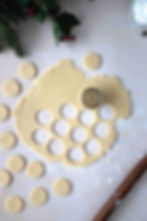 Cutting out the cookie dough with a round cutter and small shapes for the cutout center.