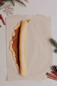 The cookie dough and spice spread is rolled into a log starting from the long side of the rectangle before the log is cut into spirals.