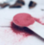 Dried hibiscus powder in a measuring spoon.