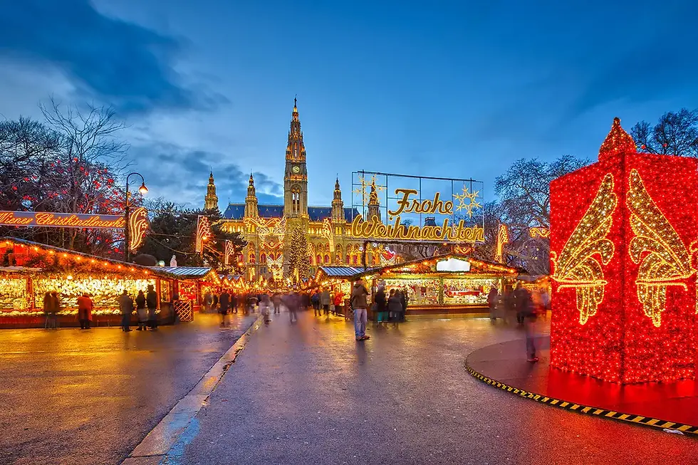 Festive Christmas market at dusk with illuminated stalls, a tall lit building, "Frohe Weihnachten" sign, and people walking. Vibrant, cheerful mood.