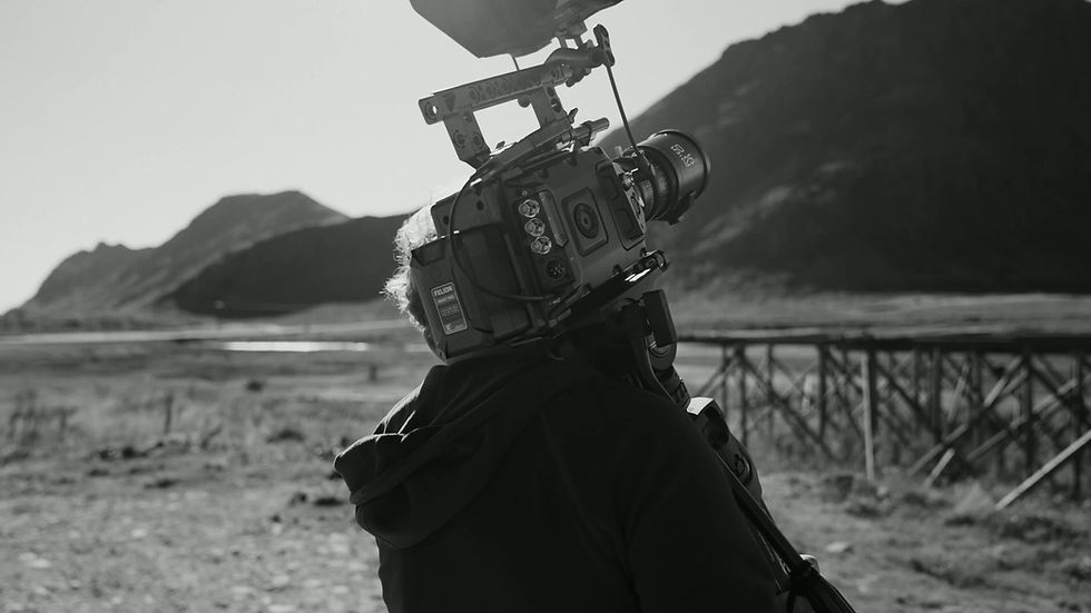 Filmmaker Carrying Film Camera in an outdoor location.
