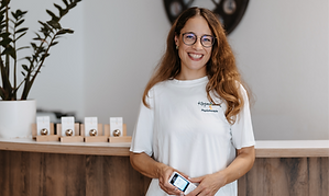 Anne steht mit dem Telefon an der Anmeldung