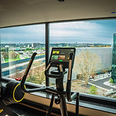 Modern fitness room with cross trainer and panoramic views over Frankfurt Airport from the 9th floor spa