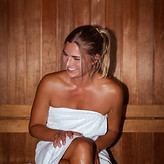 Guest relaxing in sauna at Frankfurt Airport spa with warm lighting