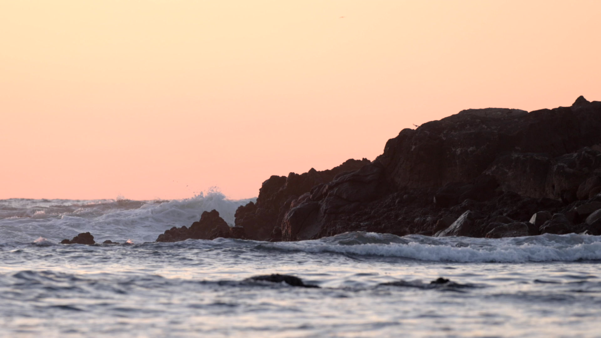 Waves breaking on the rocks at sunset