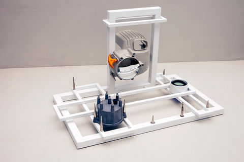 powdercoated steel scultpture with distributor cap, small engine casing, lens, mirror, threaded spikes, and hardware.