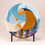 Thumbnail: A circular abstract glass sculpture featuring swirls of rust, blue, cream, and black irid glass interacting