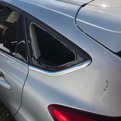 A silver car with a broken rear window and windscreen