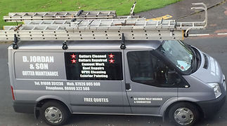 Grey maintenance van with ladders on top