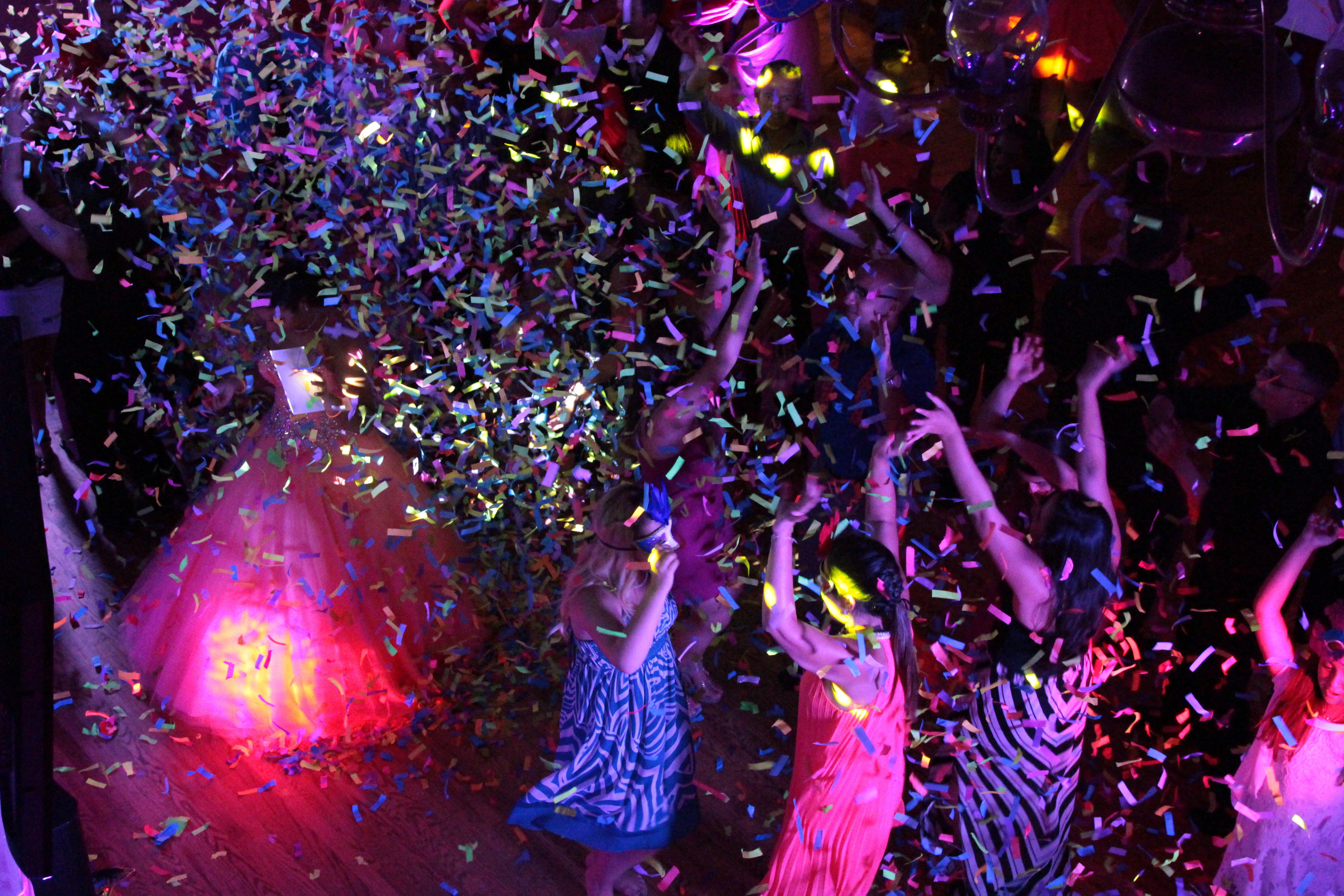 Wedding party dancing under colorful event lighting