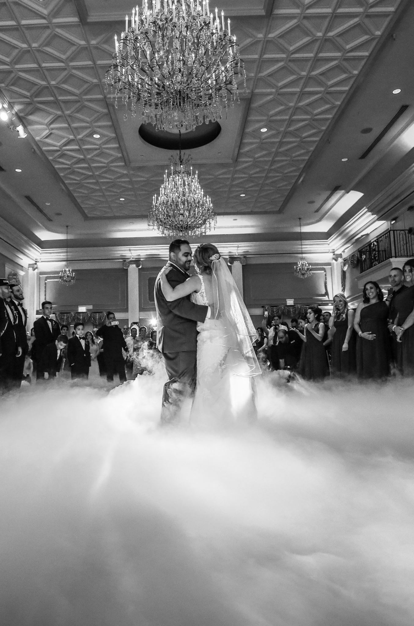 Newlyweds sharing a first dance with a low cloud effect