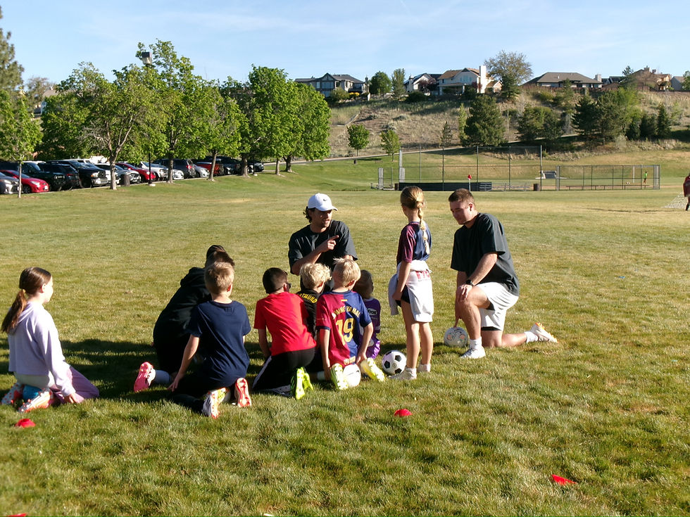 Kids and coaches on a field for private soccer training.