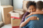 Young african woman holding home keys while hugging boyfriend in their new apartment after