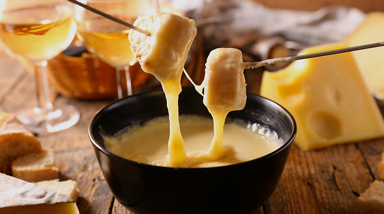 cheese fondue with wine glasses and brea