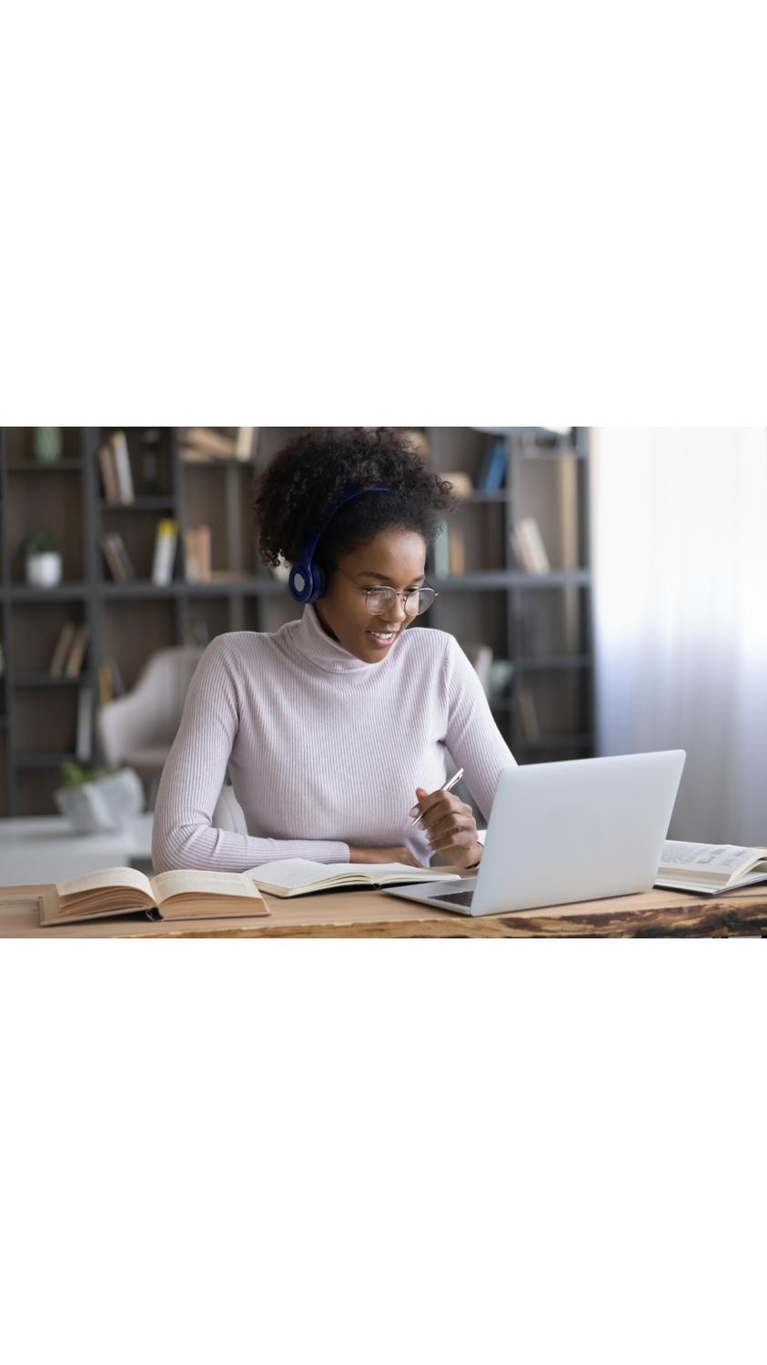 This image radiates a warm, productive energy—perfect for showcasing modern remote work or study environments. The combination of analog tools (books, pen, paper) and digital tech (laptop, headphones) reflects a hybrid workflow that’s both focused and adaptable. The natural light and cozy setting add a layer of comfort that’s ideal for branding educational services, virtual tutoring, or even professional development platforms.