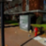 Portrait peint sur un coffret gris dans une rue.