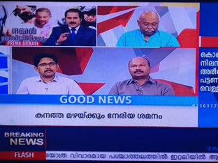 Television news broadcast with two men in discussion, three men in a split-screen above. Texts: GOOD NEWS, BREAKING NEWS. Blue and red graphics.