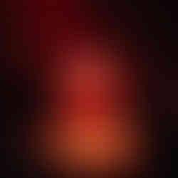 Drag Queen stands in a square of light on stage surrounded by actors, mood lighting is red for danger