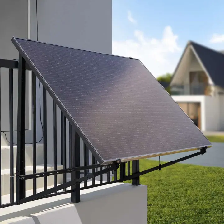 Schwarzes Solarmodul an einer verstellbaren Halterung, montiert an einem Balkon, im Außenbereich bei Tageslicht.