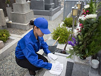 お墓を掃除する作業員