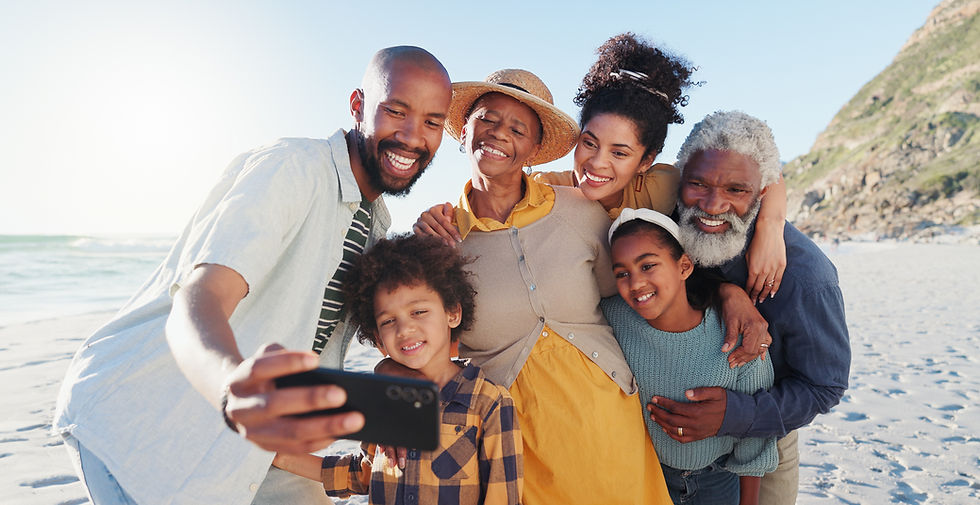 Multigenerational family smiling and taking a selfie together on a sunny beach