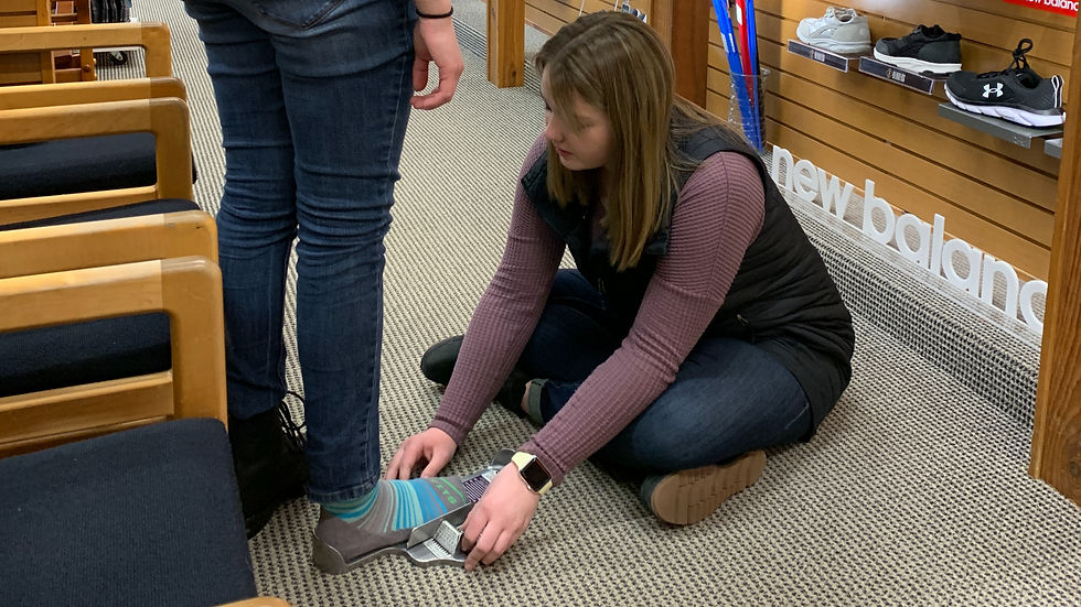 High angle view of a customer being assisted with shoe fitting