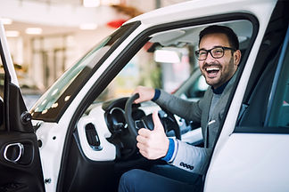 Motorista sorrindo dentro de um carro