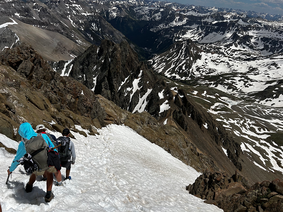 Climbers descending a steep snow traverse