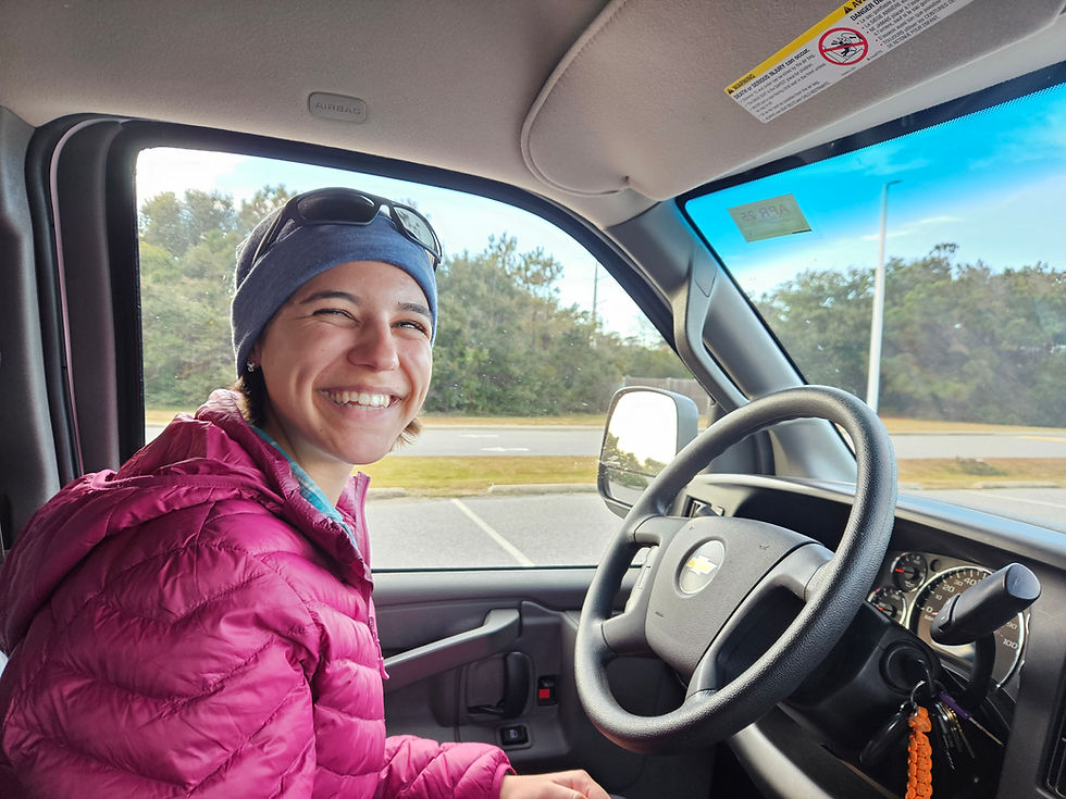 Girl in winter clothes at steering wheel inside passenger van