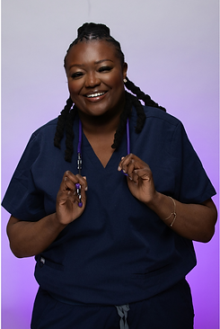 Jasmine, a UK registered midwife, smiling in navy blue scrubs while holding a purple stethoscope.