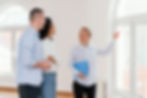smiley-female-realtor-showing-empty-house-young-couple.jpg