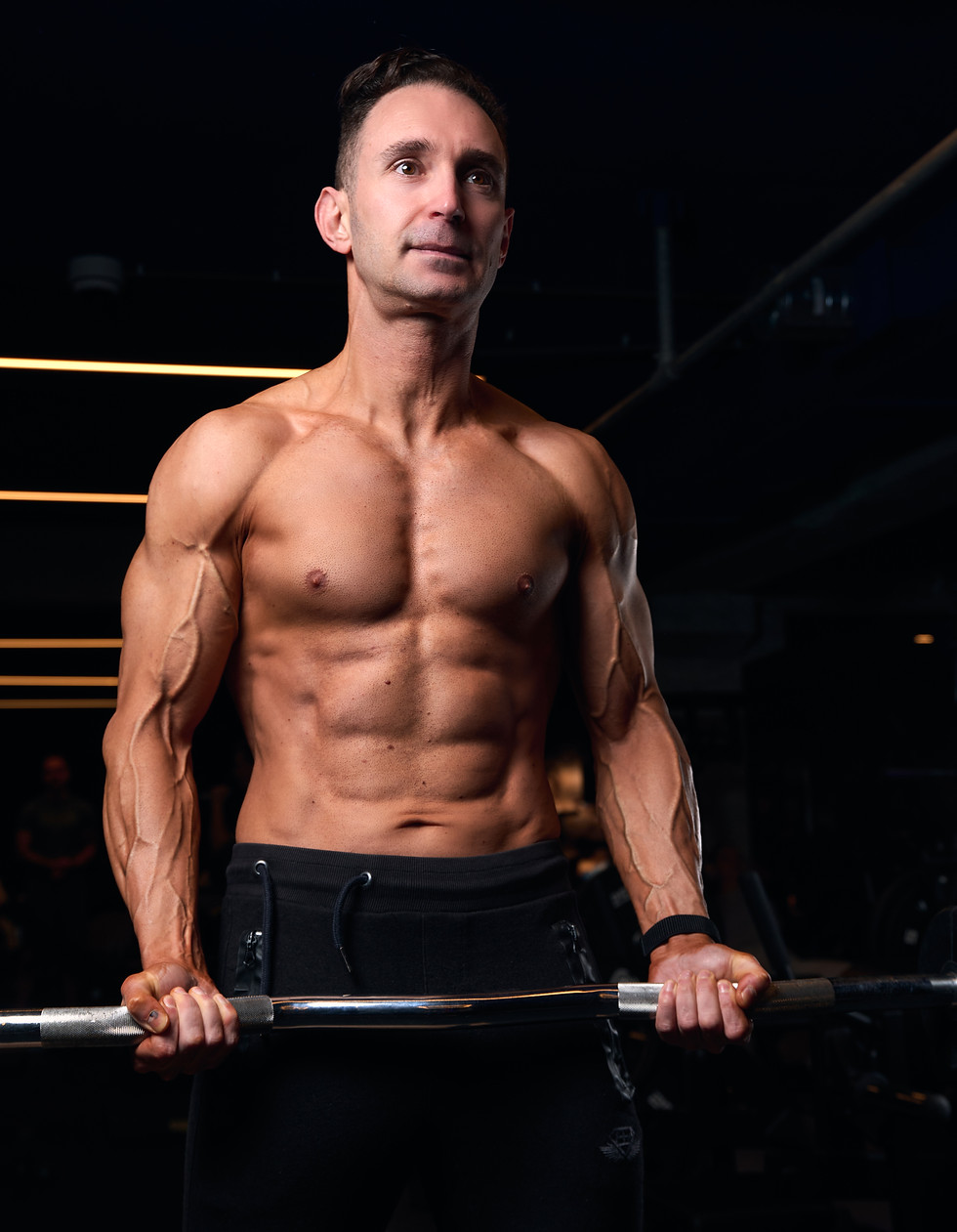 Gespierde man traint bicep curls bij JB Coaching