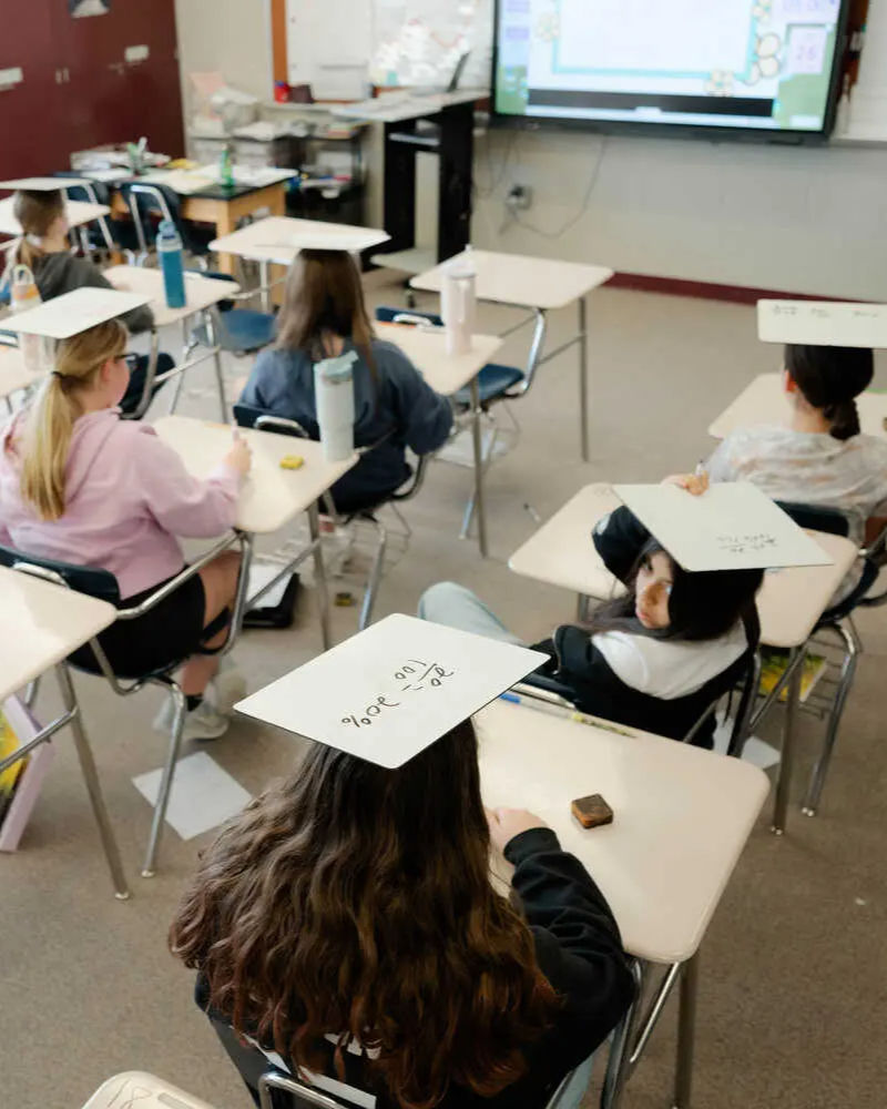 Sixth-graders write math answers on mini-whiteboards, which they put on their heads to show they're ready to be called on. Photo: David Robert Elliott/New York Times