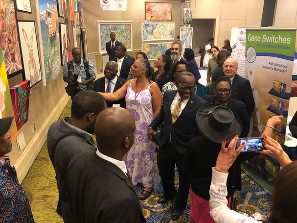 Nicole Collie is with The Prime Minister of The Bahamas and showing him art
