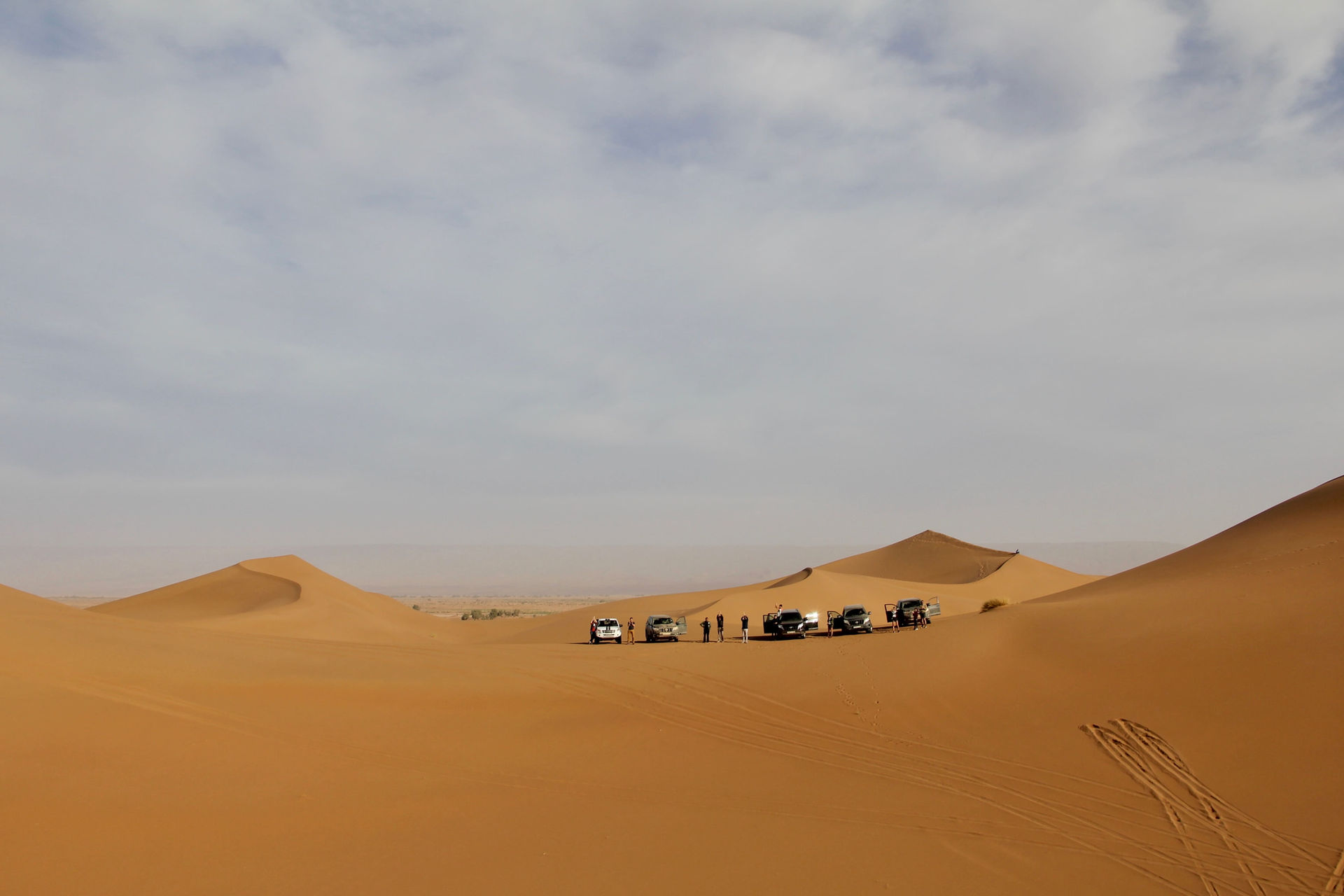 Plusieurs véhicules tout-terrain sur les dunes de sable, ALLMOOV MARRAKECH, paysage désertique.
