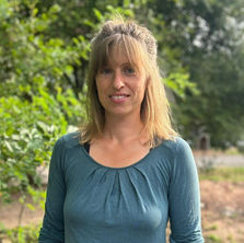 Frau mit blauem Pulli und langen brauen Haaren