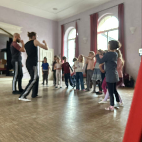 Kinder, die in einer Reihe stehen und eine Boxbewegung durchführen.