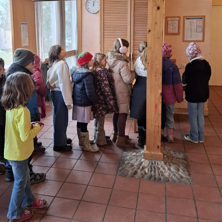 Schulkinder, die in einer Schlange im Flur stehen. 