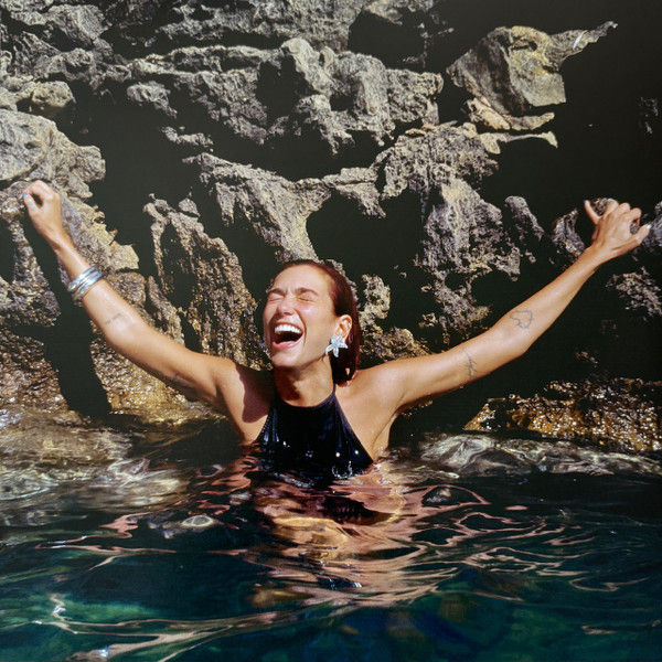 Thumbnail: Joyful woman in water near rocks