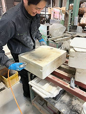 製品を石膏型から外す作業をしている男性