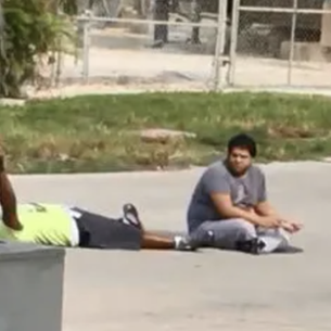 Cellphone video shows caretaker lying in the street before being shot by police