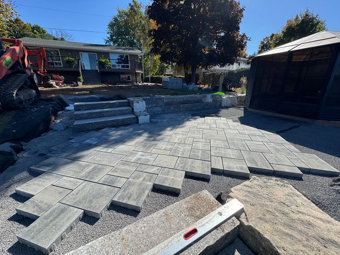 construction of interlock patio with natural armour stone stairs, with armour stone retaining wall. 
