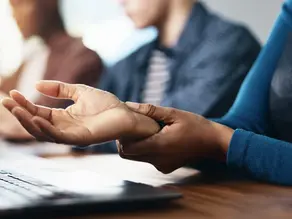 injured worker holding her wrist indicating she may be suffering from carpel tunnel. 