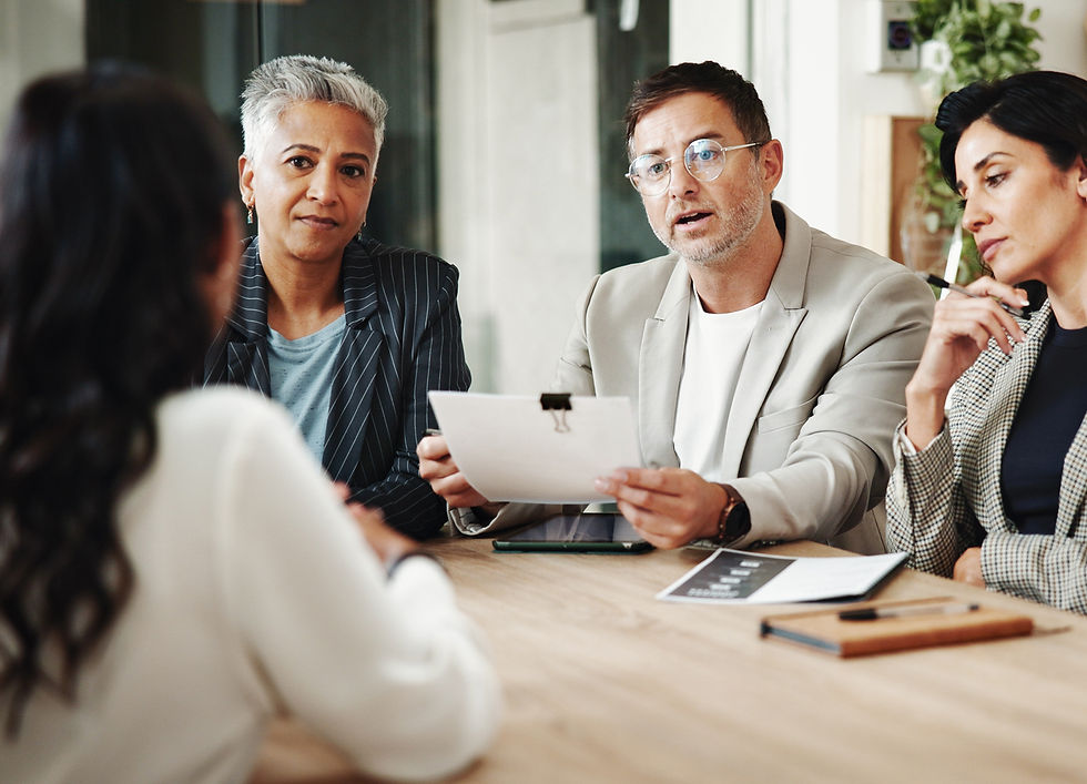 woman interviewing for a job with a group of three: two women and a man, with concerned looks on their faces.